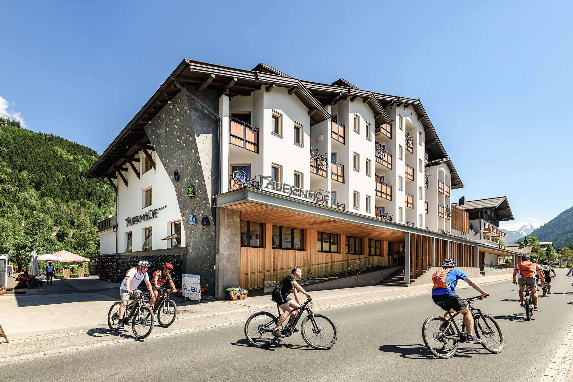 Aussenansicht des Hotels Tauernhof in Flachau mit Radfahrern im Vordergrund