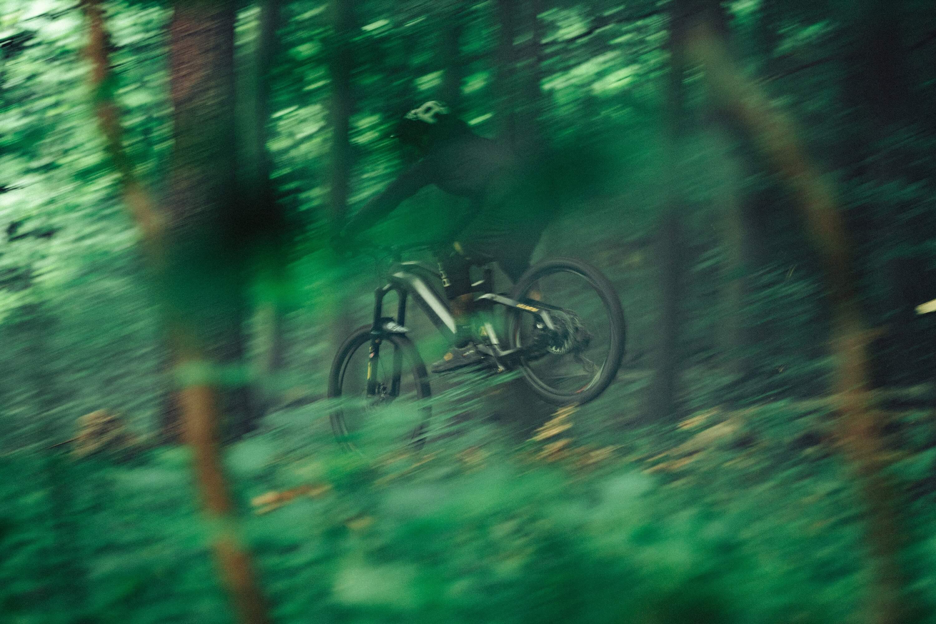 Someone riding fast through the woods on their Haibike AllMtn SE eMTB