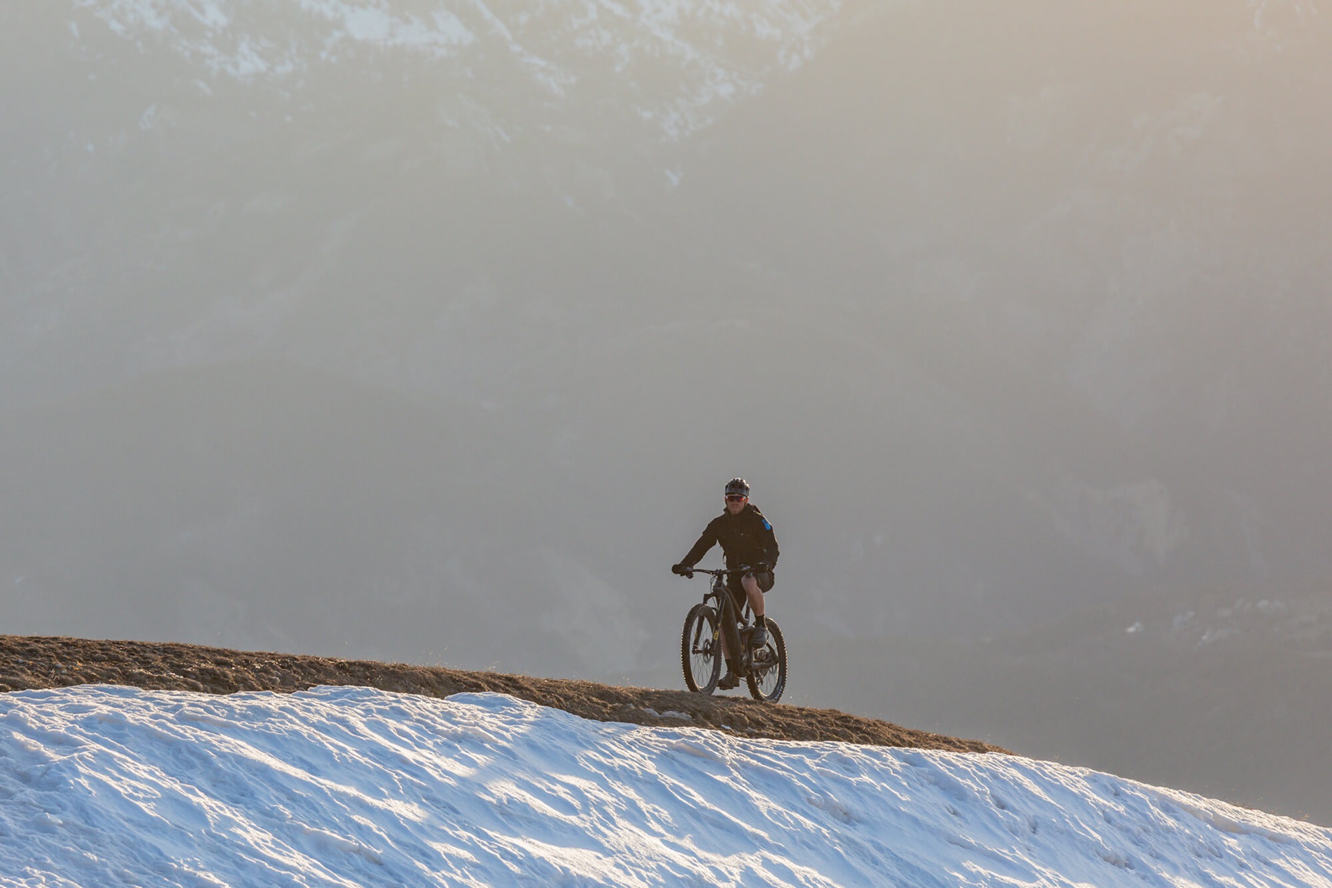 Xavier Marovelli sur son vélo Haibike AllMtn SE à travers Valberg avec de la neige à côté de la piste de VTT