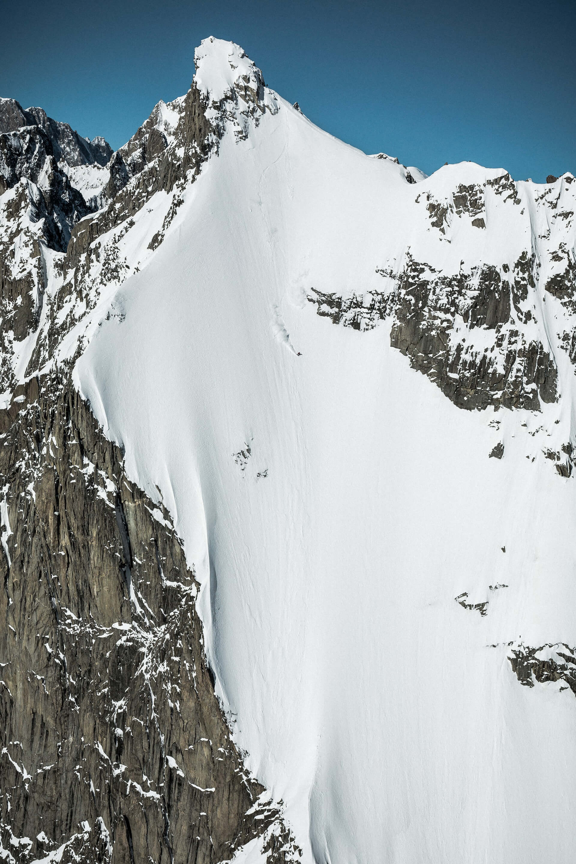 Prise de vue en grand angle de Haibike Hero Victor Delerue debout au sommet d'une haute montagne en attente de descendre avec son snowboard