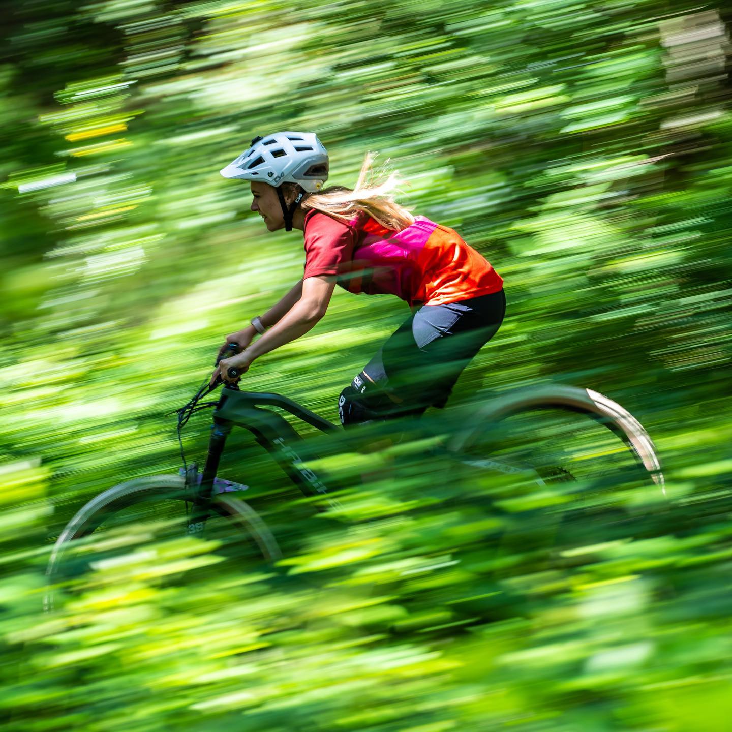 Haibike Hero Kara Beal riding her Haibike AllMtn 6 through a green forest